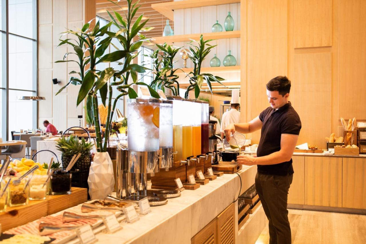 Avani Plus Riverside Bangkok Hotel Exterior photo A hotel employee working at a buffet